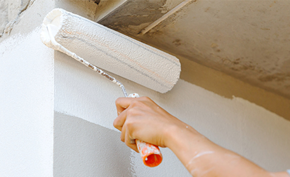 Close Up Of Painter Arm Painting A Wall With Paint Roller